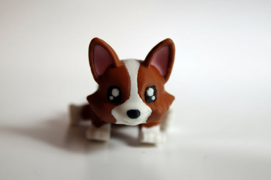 Small figurine of a dog with brown and white fur on a light background