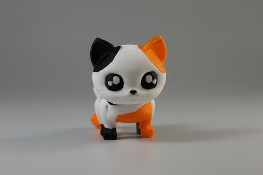 Small figurine of a black, white, and orange cat